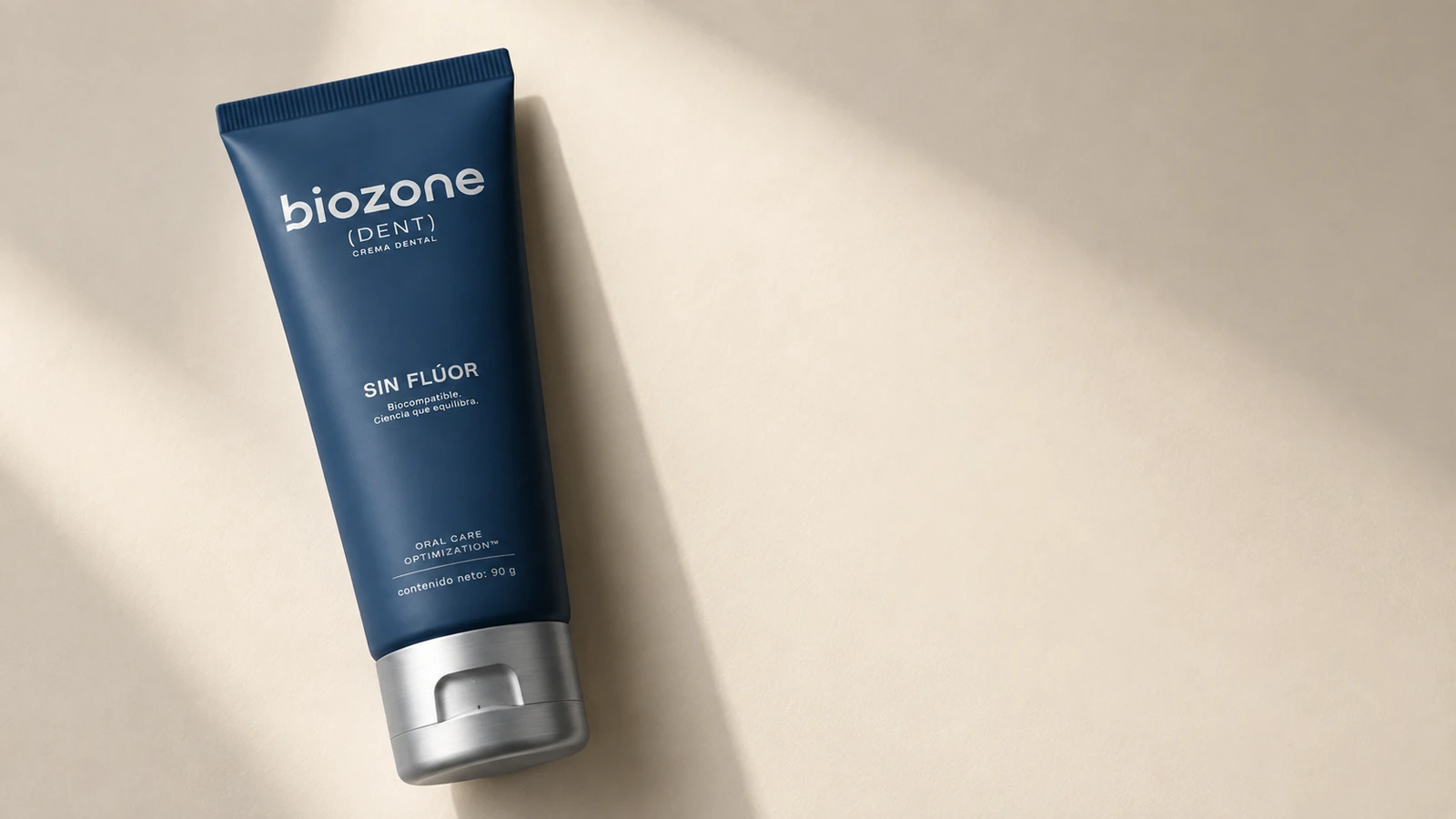 Tubo de Biozone Dent en diagonal sobre una superficie crema
